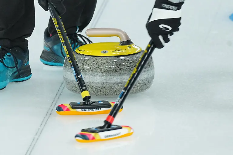 Olympia-Olympische-Winterspiele-Mailand-Cortina-2026-Curling-Maenner-Vorrunde-Tschechien-Deutschland-Spieltag-9-ein-gelber-Spielstein-und-ein-Besen-vom-Team-Deutschland