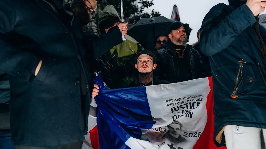 A-protester-in-a-wheelchair-with-a-French-flag-bearing-the-words-dead-for-our-sisters-dead-for-France-justice-for-Quentin-during-the-gathering-in-tribute-to-Quentin-D-a-young-activist-who-died-from-his-injuries-after-being-violently-attacked-in-Lyon-on-Place-de-la-Sorbonne-in-Paris-France-the-15-february-2026-un-manifestant-en-fauteuil-roulant-avec-un-drapeau-francais-avec-marque-mort-pour-nos-soeur-mort-pour-la-france-justice-pour-quentin-lors-du-rassemblement-en-hommage-a-Quentin-D-jeune-militant-decede-suite-a-ses-blessures-apres-avoir-ete-violemment-agresse-a-lyon-sur-la-place-de-la-Sorbonne-a-Paris-en-France-le-15-fevrier-2026