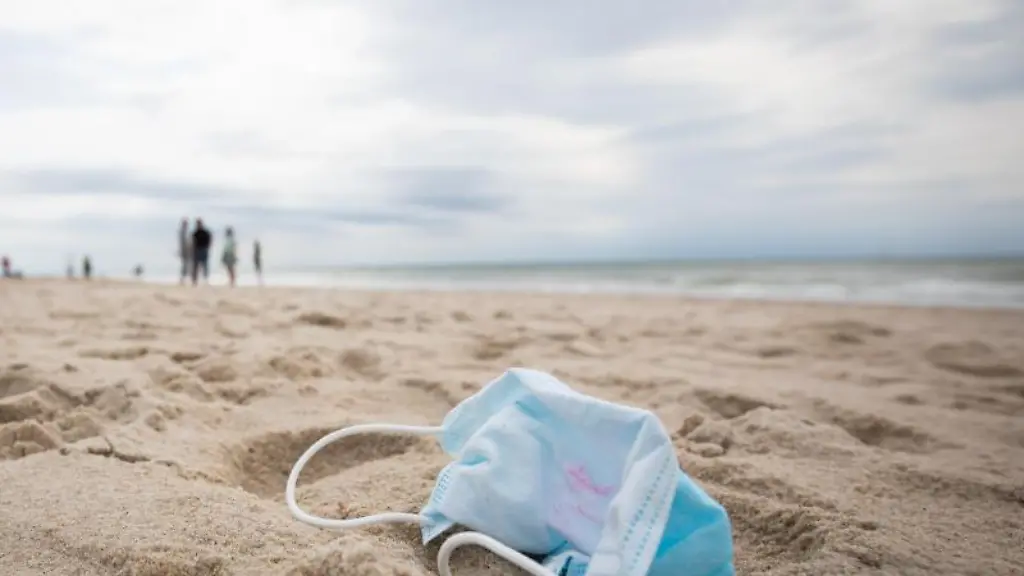 Ein-gebrauchter-Mundschutz-mit-Resten-von-Lippenstift-am-Strand-von-Westerland-auf-Sylt