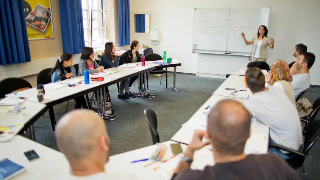 Die-Deutschlehrerin-Guelsen-Landshuter-h-r-geht-mit-Teilnehmern-eines-Integrationskurses-am-14-07-2016-im-Bildungszentrum-in-Nuernberg-Bayern-eine-Sprachuebung-durch-Zuwanderer-und-Fluechtlinge-sollen-im-Integrationskurs-deutsch-lernen-und-Grundkenntnisse-ueber-die-Bundesrepublik-bekommen-Foto-Daniel-Karmann-dpa-zu-dpa-Erfolgsmodell-Integrationskurs-vom-12-08