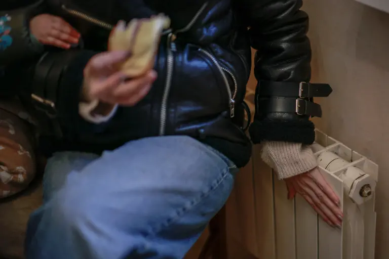 Yuliia-Davydenko-40-checks-a-radiator-at-her-family-s-apartment-where-the-temperature-does-not-exceed-3-degrees-Celsius-about-37-degrees-Fahrenheit-due-to-no-heating-or-hot-water-and-frequent-power-outages-amid-Russia-s-attack-on-Ukraine-in-Kyiv-Ukraine-February-1-2026-Waves-of-Russian-attacks-over-the-past-four-months-left-hundreds-of-thousands-without-electricity-and-water-making-this-the-most-devastating-winter-since-the-war-started-for-the-city-s-three-million-people-and-so-the-Davydenko-family-made-the-choice-to-stay-at-the-family-owned-Piggy-Cafe-Kyiv-with-power-supplied-by-a-generator-and-heating-The-point-when-we-decide-to-leave-Kyiv-again-would-be-when-Russian-troops-are-10-12-km-from-the-city-That-s-it-Yuliia-Davydenko-40-said-REUTERS-Alina-Smutko-SEARCH-SMUTKO-COLD-FAMILY-FOR-THIS-STORY-SEARCH-WIDER-IMAGE-FOR-ALL-STORIES