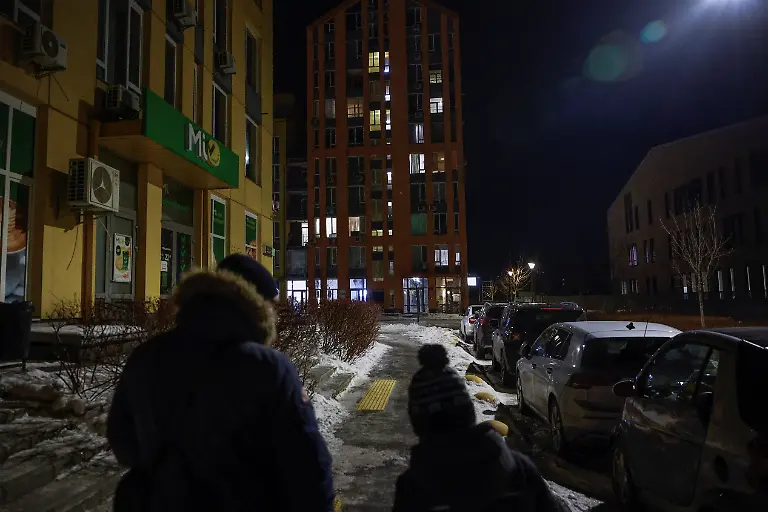 Denys-Davydenko-40-and-his-son-Maksym-11-walk-along-a-snowy-residential-street-towards-a-bookstore-near-their-family-cafe-as-their-apartment-has-no-heating-or-hot-water-and-faces-frequent-power-outages-amid-Russia-s-attack-on-Ukraine-in-Kyiv-Ukraine-February-2-2026-Waves-of-Russian-attacks-over-the-past-four-months-left-hundreds-of-thousands-without-electricity-and-water-making-this-the-most-devastating-winter-since-the-war-started-and-so-the-Davydenko-family-made-the-choice-to-stay-at-the-family-owned-Piggy-Cafe-Kyiv-with-power-supplied-by-a-generator-and-heating-Maksym-likes-it-Denys-joked-about-their-new-reality-He-actually-says-that-at-home-we-have-to-do-household-chores-Now-there-s-no-dish-washing-cleaning-walking-the-dogs-So-he-is-happy-about-that-REUTERS-Alina-Smutko-SEARCH-SMUTKO-COLD-FAMILY-FOR-THIS-STORY-SEARCH-WIDER-IMAGE-FOR-ALL-STORIES