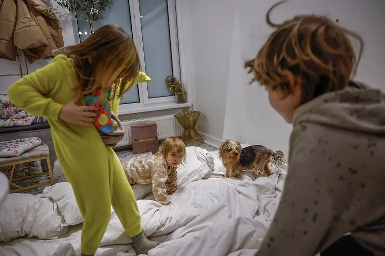 Siblings-Maksym-11-Tymofiy-6-and-Stephanie-Davydenko-2-play-on-an-improvised-bed-on-the-floor-of-their-family-s-cafe-where-they-are-staying-because-their-apartment-has-no-heating-or-hot-water-and-faces-frequent-power-outages-amid-Russia-s-attack-on-Ukraine-in-Kyiv-Ukraine-February-1-2026-Waves-of-Russian-attacks-over-the-past-four-months-left-hundreds-of-thousands-without-electricity-and-water-making-this-the-most-devastating-winter-since-the-war-started-and-so-the-Davydenko-family-made-the-choice-to-stay-at-the-family-owned-Piggy-Cafe-Kyiv-with-power-supplied-by-a-generator-and-heating-Maksym-likes-it-the-father-Denys-Davydenko-40-joked-about-their-new-reality-He-actually-says-that-at-home-we-have-to-do-household-chores-Now-there-s-no-dish-washing-cleaning-walking-the-dogs-So-he-is-happy-about-that-REUTERS-Alina-Smutko-SEARCH-SMUTKO-COLD-FAMILY-FOR-THIS-STORY-SEARCH-WIDER-IMAGE-FOR-ALL-STORIES
