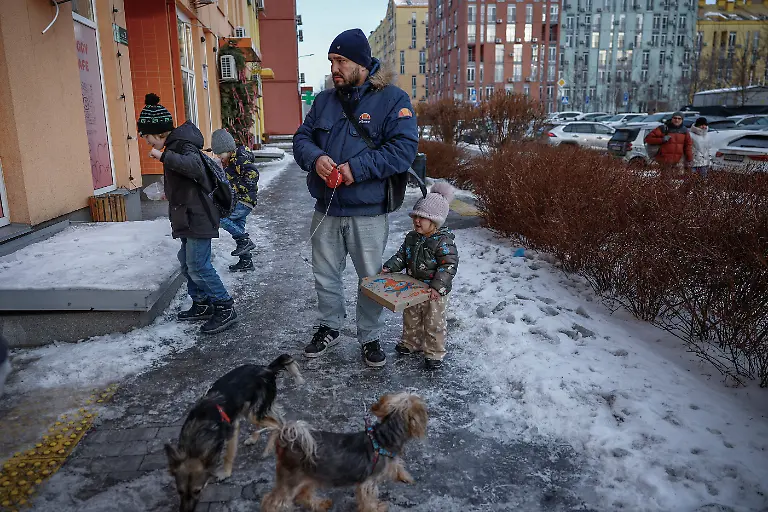 Denys-Davydenko-40-walks-the-family-s-two-dogs-with-his-children-Maksym-11-Tymofiy-6-and-Stephanie-2-before-dropping-off-the-two-eldest-at-school-amid-Russia-s-attack-on-Ukraine-in-Kyiv-Ukraine-February-2-2026-Waves-of-Russian-attacks-over-the-past-four-months-left-hundreds-of-thousands-without-electricity-and-water-making-this-the-most-devastating-winter-since-the-war-started-and-so-the-Davydenko-family-made-the-choice-to-stay-at-the-family-owned-Piggy-Cafe-Kyiv-with-power-supplied-by-a-generator-and-heating-Maksym-likes-it-Denys-joked-about-their-new-reality-He-actually-says-that-at-home-we-have-to-do-household-chores-Now-there-s-no-dish-washing-cleaning-walking-the-dogs-So-he-is-happy-about-that-REUTERS-Alina-Smutko-SEARCH-SMUTKO-COLD-FAMILY-FOR-THIS-STORY-SEARCH-WIDER-IMAGE-FOR-ALL-STORIES