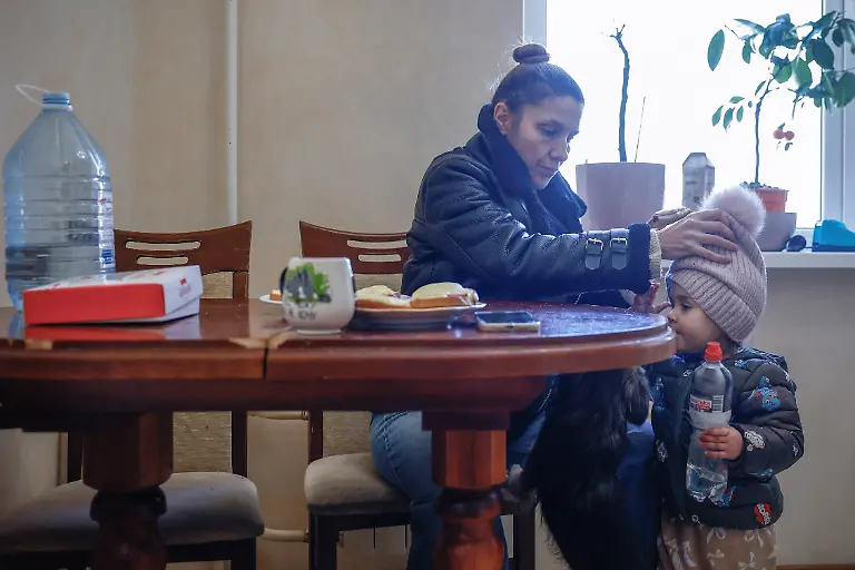 Yuliia-Davydenko-40-adjusts-the-hat-of-her-daughter-Stephanie-2-in-their-apartment-s-kitchen-which-has-no-heating-or-hot-water-and-experiences-frequent-power-outages-amid-Russia-s-attack-on-Ukraine-in-Kyiv-Ukraine-February-1-2026-Waves-of-Russian-attacks-over-the-past-four-months-left-hundreds-of-thousands-without-electricity-and-water-making-this-the-most-devastating-winter-since-the-war-started-for-the-city-s-three-million-people-and-so-the-Davydenko-family-made-the-choice-to-stay-at-the-family-owned-Piggy-Cafe-Kyiv-with-power-supplied-by-a-generator-and-heating-The-point-when-we-decide-to-leave-Kyiv-again-would-be-when-Russian-troops-are-10-12-km-from-the-city-That-s-it-Yuliia-said-REUTERS-Alina-Smutko-SEARCH-SMUTKO-COLD-FAMILY-FOR-THIS-STORY-SEARCH-WIDER-IMAGE-FOR-ALL-STORIES