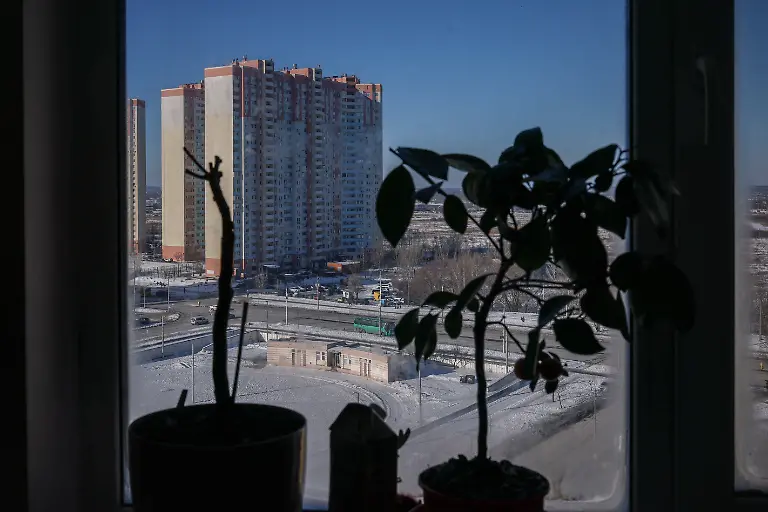 Apartment-buildings-of-the-residential-area-which-has-no-heating-or-hot-water-and-experiences-frequent-power-outages-are-seen-through-a-window-at-the-Davydenko-family-s-apartment-amid-Russia-s-attack-on-Ukraine-in-Kyiv-Ukraine-February-1-2026-Waves-of-Russian-attacks-over-the-past-four-months-left-hundreds-of-thousands-without-electricity-and-water-making-this-the-most-devastating-winter-since-the-war-started-for-the-city-s-three-million-people-and-so-the-Davydenko-family-made-the-choice-to-stay-at-the-family-owned-Piggy-Cafe-Kyiv-with-power-supplied-by-a-generator-and-heating-The-point-when-we-decide-to-leave-Kyiv-again-would-be-when-Russian-troops-are-10-12-km-from-the-city-That-s-it-the-mother-Yuliia-Davydenko-40-said-REUTERS-Alina-Smutko-SEARCH-SMUTKO-COLD-FAMILY-FOR-THIS-STORY-SEARCH-WIDER-IMAGE-FOR-ALL-STORIES