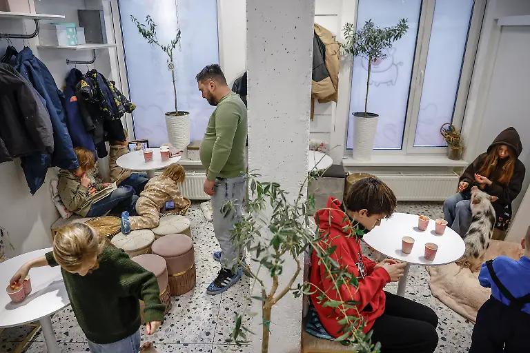 People-sit-at-the-Davydenko-s-family-cafe-where-the-family-is-staying-because-their-apartment-has-no-heating-or-hot-water-and-faces-frequent-power-outages-amid-Russia-s-attack-on-Ukraine-in-Kyiv-Ukraine-February-1-2026-Waves-of-Russian-attacks-over-the-past-four-months-left-hundreds-of-thousands-without-electricity-and-water-making-this-the-most-devastating-winter-since-the-war-started-and-so-the-Davydenko-family-made-the-choice-to-stay-at-the-family-owned-Piggy-Cafe-Kyiv-with-power-supplied-by-a-generator-and-heating-Maksym-likes-it-the-father-Denys-Davydenko-40-joked-about-their-new-reality-He-actually-says-that-at-home-we-have-to-do-household-chores-Now-there-s-no-dish-washing-cleaning-walking-the-dogs-So-he-is-happy-about-that-REUTERS-Alina-Smutko-SEARCH-SMUTKO-COLD-FAMILY-FOR-THIS-STORY-SEARCH-WIDER-IMAGE-FOR-ALL-STORIES