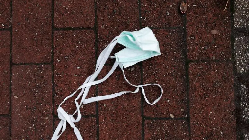 Auf-einer-Strasse-liegt-ein-Mund-Nasen-Schutz-auf-dem-Boden
