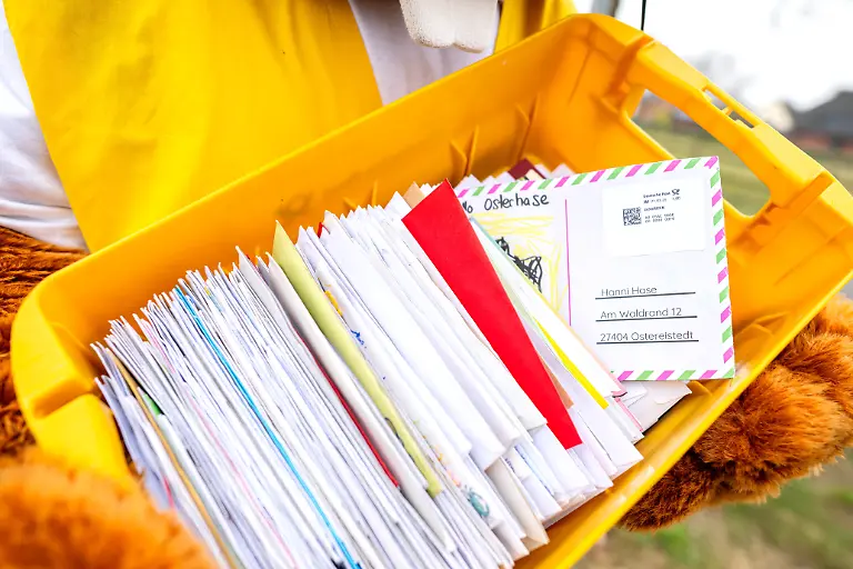 Hanni-Hase-laeuft-mit-einer-Kiste-voller-Briefe-durch-Ostereistedt-zu-dpa-Osterpostamt-beantwortet-75