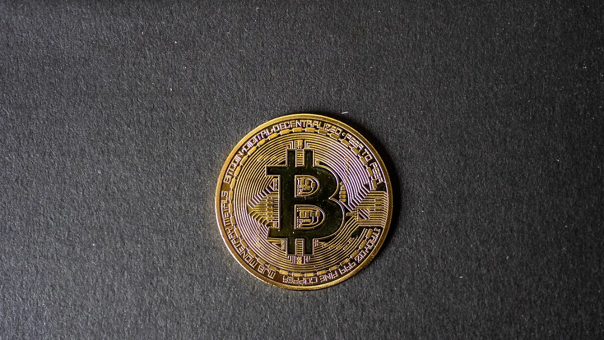 Nahaufnahme einer Bitcoin Münze auf dunkler Oberfläche