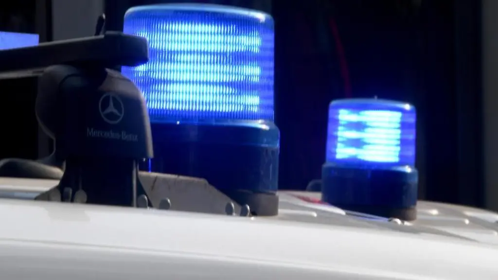 Die-Blaulichter-sind-auf-den-Daechern-von-Polizeifahrzeugen-zu-sehen