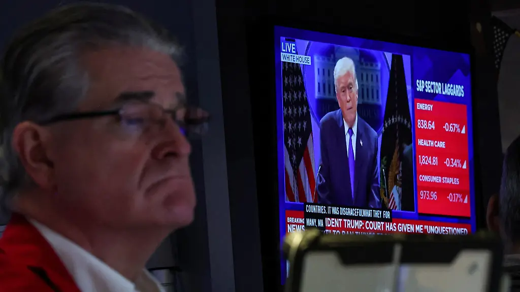 A-trader-works-on-the-floor-as-a-screen-displays-U-S-President-Donald-Trump-during-a-press-briefing-at-the-White-House-following-the-Supreme-Court-s-ruling-on-tariffs-at-the-New-York-Stock-Exchange-NYSE-in-New-York-City-U-S-February-20-2026