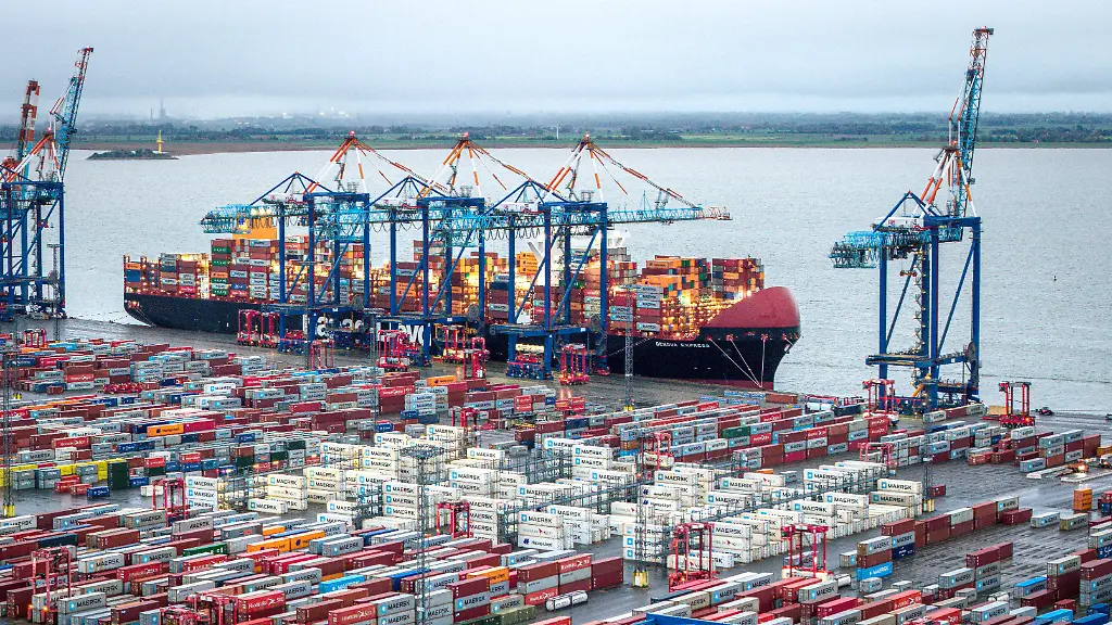 Containerschiffe-liegen-im-Hafen-Aufnahme-mit-einer-Drohne-Zoelle-erschweren-und-verteuern-den-Handel-die-Konjunktur-lahmt-doch-das-Geschaeft-deutscher-Schifffahrtsunternehmen-zeigt-sich-krisenfest