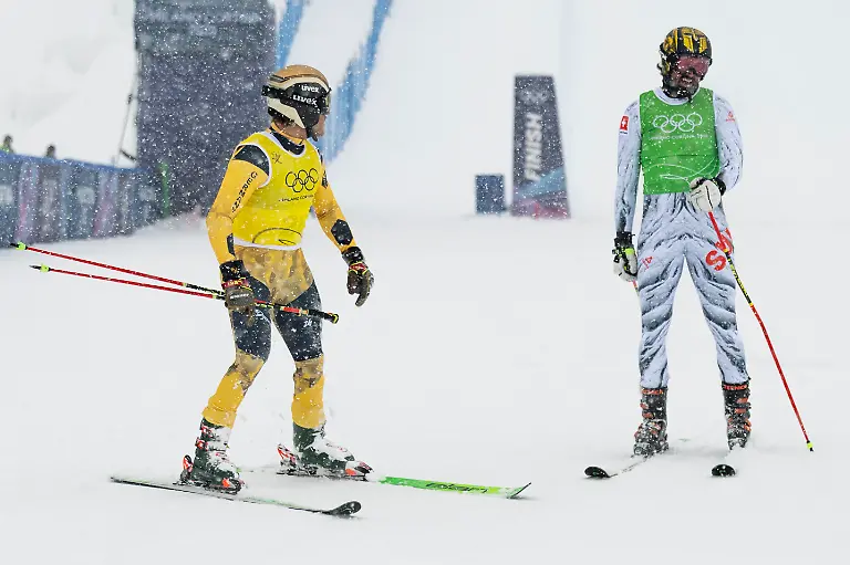 Tim-Hronek-of-Germany-left-and-Ryan-Regez-of-Switzerland-right-react-in-the-finish-area-during-the-men-s-Freestyle-Skiing-Ski-Cross-Semifinal-at-the-2026-Olympic-Winter-Games-in-Livigno-Italy-on-Saturday-February-21-2026