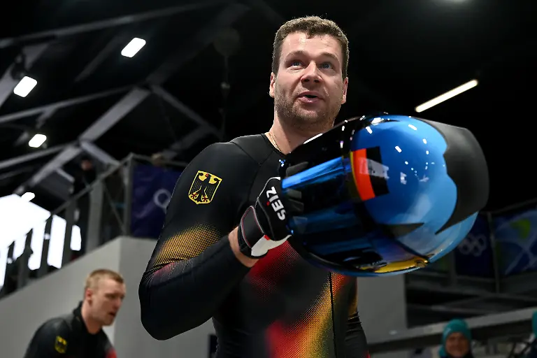 Olympia-Olympische-Winterspiele-Mailand-Cortina-2026-Bob-Viererbob-Maenner-Durchgang-3-im-Cortina-Sliding-Centre-Johannes-Lochner-Pilot-Deutschland-r-reagiert-im-Ziel-Dahinter-geht-Anschieber-Thorsten-Margis