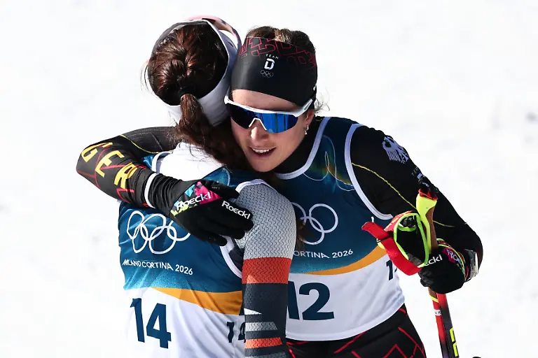 Olympia-Olympische-Winterspiele-Mailand-Cortina-2026-Ski-nordisch-Langlauf-50-km-Massenstart-klassisch-Darija-Neprjajeva-Individueller-Neutraler-Athlet-AIN-und-Katharina-Hennig-Dotzler-r-Deutschland-umarmen-sich-nach-dem-Rennen