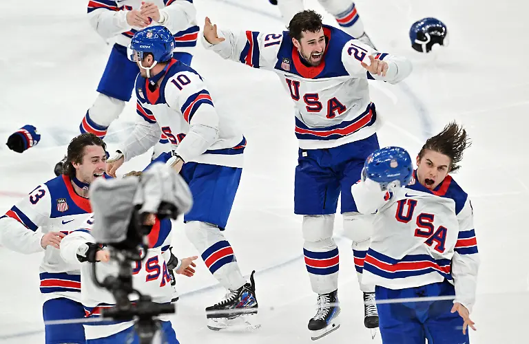 Olympia-Olympische-Winterspiele-Mailand-Cortina-2026-Eishockey-Maenner-Kanada-USA-Finalrunde-Finale-Jack-Hughes-vorne-r-USA-jubelt-mit-den-Teamkollegen-ueber-seinen-Siegtreffer