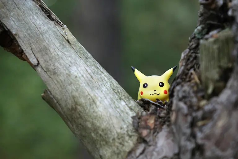 ILLUSTRATION-Die-Pokemon-Figur-Pikachu-ist-hinter-einem-Baumstamm-zu-sehen-aufgenommen-am-02-09-2016-Pokemon-sind-Fantasiewesen-in-der-gleichnamigen-Serie-von-Videospielen-Die-Spiele-wurden-urspruenglich-von-Satoshi-Tajiri-und-der-japanischen-Spielesoftwarefirma-GAME-FREAK-Inc-entwickelt-und-stellen-eines-der-wichtigsten-Franchises-des-Publishers-Nintendo-dar-Die-Pokemon-koennen-vom-Spieler-gefangen-gesammelt-und-trainiert-werden-Dem-Erfolg-des-1996-erstmals-veroeffentlichten-Spiels-folgten-eine-Anime-Fernsehserie-ein-Sammelkartenspiel-eine-grosse-Zahl-von-Merchandising-Produkten-und-seit-1998-bisher-18-Kinofilme-Die-Videospiele-des-Pokemon-Franchises-verkauften-sich-weltweit-zusammen-ueber-200-Millionen-Mal-Insofern-kann-die-Reihe-als-eines-der-erfolgreichsten-Produkte-der-modernen-Spieleindustrie-betrachtet-werden