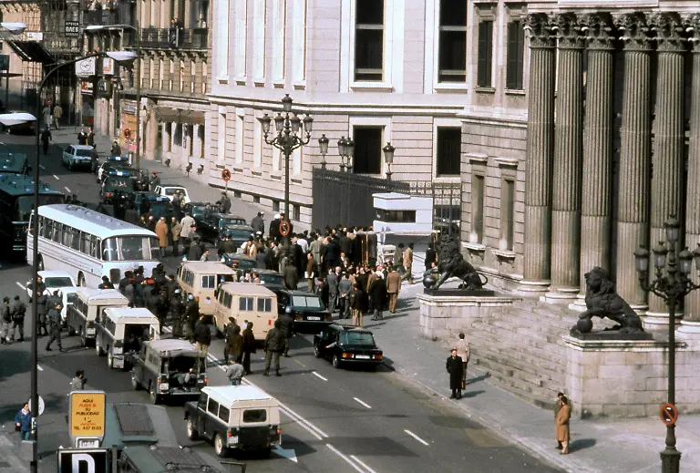 Polizei-und-Militaer-umstellen-am-23-2-1981-das-Parlamentsgebaeude-in-Madrid-nachdem-Oberstleutnant-Antonio-Tejero-Molina-mit-mehr-als-200-Mann-der-paramilitaerischen-Guardia-Civil-das-Parlament-gestuermt-und-die-Abgeordneten-mitsamt-der-Regierung-als-Geiseln-genommen-hat-Durch-den-mutigen-Einsatz-von-Koenig-Juan-Carlos-fuer-die-demokratische-Ordnung-brach-der-Putschversuch-nach-18-Stunden-zusammen-Wichtige-Militaers-wollten-sich-zudem-den-Umstuerzlern-nicht-anschliessen-Tejero-wurde-zu-30-Jahren-Gefaengnis-verurteilt