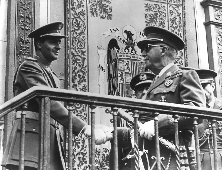 Prinz-Juan-Carlos-von-Spanien-begruesst-den-Diktator-General-Franco-r-am-31-Mai-1967-in-Madrid-anlaesslich-der-Feierlichkeiten-zum-Jahrestag-des-Endes-des-Spanischen-Buergerkriegs-Juan-Carlos-Alfonso-Victor-Maria-de-Borbon-y-Borbon-wurde-am-5-Januar-1938-in-Rom-geboren-Der-spanische-Diktator-Franco-schlug-Juan-Carlos-am-22-Juli-1969-als-seinen-Nachfolger-vor-am-23-Juli-wurde-dieser-als-Prinz-von-Spanien-vereidigt-Nach-Francos-Tod-bestieg-Juan-Carlos-am-27-November-1975-in-einem-feierlichen-Staatsakt-den-Thron-Koenig-Juan-Carlos-der-lange-als-gefuegige-Kreatur-des-Diktators-galt-erklaerte-sein-jahrelanges-Schweigen-mit-Ich-habe-gelernt-zu-beobachten-und-zu-schweigen-und-entwickelte-sich-in-den-folgenden-Jahren-zu-einer-treibenden-demokratischen-Kraft-in-seinem-Land-Im-In-und-Ausland-erfreut-sich-der-sportliche-Monarch-einer-grossen-Popularitaet-Juan-Carlos-ist-seit-dem-14-Mai-1962-mit-Prinzessin-Sofia-von-Griechenland-verheiratet-der-Ehe-entstammen-die-Kinder-Elena-Cristina-und-Felipe