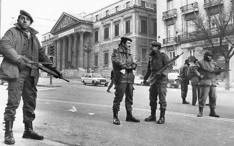FILE-In-this-Feb-1981-file-photo-members-of-the-the-anti-riot-squad-of-the-National-police-stand-guard-at-the-square-in-front-of-the-Spanish-Cortes-Parliament-seen-in-the-background-in-Madrid-Spain-while-inside-the-lower-house-about-150-armed-Civil-Guards-still-held-the-deputies-hostage-King-Felipe-VI-Spanish-lawmakers-and-others-on-Tuesday-Feb-23-2021-are-marking-40-years-since-a-paramilitary-coup-attempt-failed-to-derail-the-country-s-peaceful-transition-to-democracy-The-anniversary-has-been-obscured-by-the-absence-of-Juan-Carlos-I-the-former-monarch-now-beset-by-financial-scandals