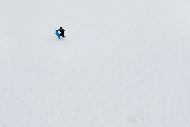 Kids-climb-up-a-hill-while-sledding-Monday-Feb-23-2026-in-Kings-Park-N-Y