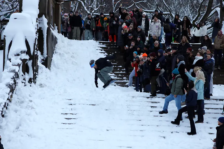 Young-New-Yorkers-in-Central-Park-Manhattan-jump-in-the-snow-in-New-York-City-USA-on-February-23-after-the-snowstorm-passes-The-snow-turns-into-a-celebration-in-Central-Park-where-hundreds-of-citizens-come-out-to-experience-the-winter-landscape-The-young-people-improvise-ski-slopes-on-Bethesda-Terrace