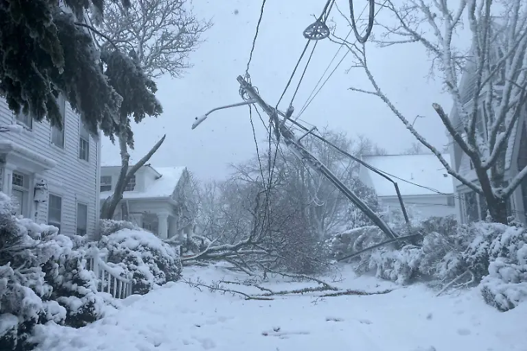 Snow-covers-the-ground-as-a-power-pole-is-suspended-after-lines-were-pulled-down-by-a-fallen-tree-during-a-winter-storm-in-Edgartown-Massachusetts-U-S-February-23-2026