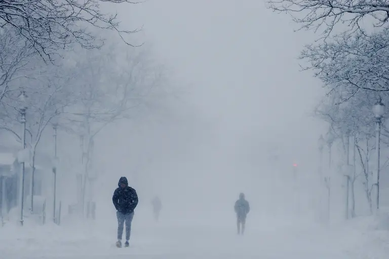 People-walk-along-Newbury-Street-during-a-winter-blizzard-snow-storm-in-Boston-Massachusetts-U-S-February-23-2026