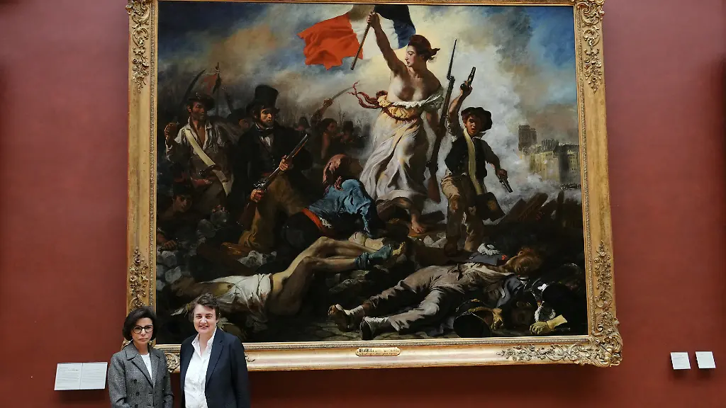 French-Culture-Minister-Rachida-Dati-L-and-Louvre-director-Laurence-des-Cars-pose-during-the-return-to-exhibition-gallery-of-the-painting-La-Liberte-guidant-le-peuple-Liberty-Leading-the-People-1830-by-French-artist-Eugene-Delacroix-following-six-month-of-restoration-work-at-the-Louvre-Museum-in-Paris-on-April-30-2024-The-public-will-discover-the-true-colours-the-iconic-painting-yellowed-by-decades-of-layers-of-varnish-and-grime-when-the-artwork-goes-back-on-display-at-the-Louvre-on-May-2-2024-following-six-month-of-restoration-work