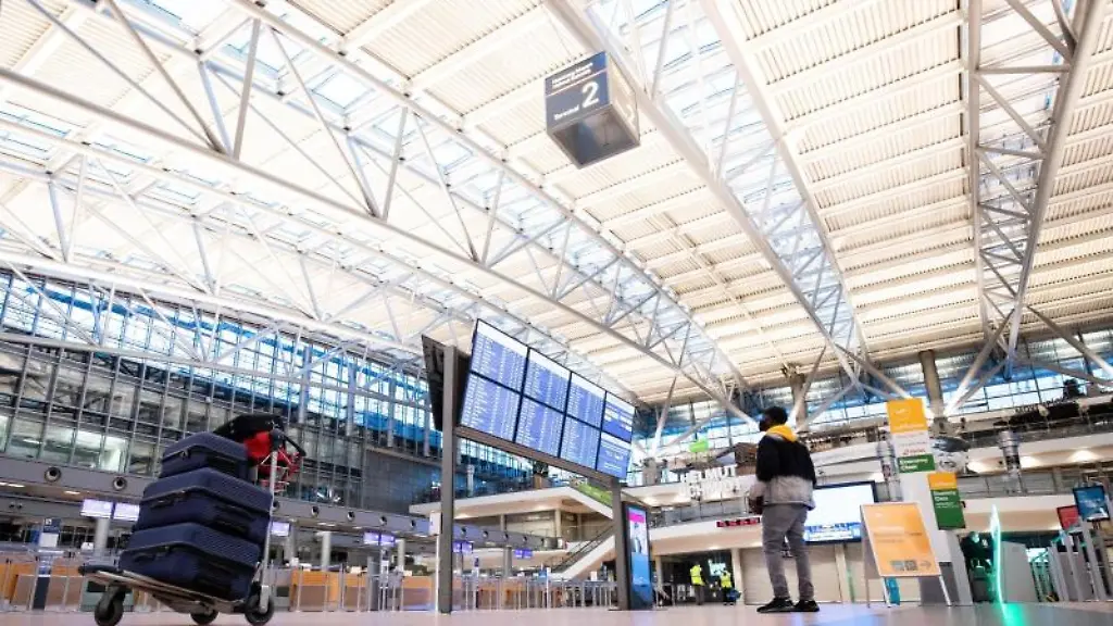 Ein-Fluggast-steht-vor-der-Anzeigetafel-in-der-Abflughalle-im-Terminal-2-am-Flughafen-Hamburg