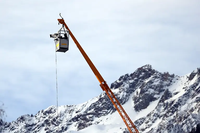 Luftiger-Arbeitsplatz-Kameramann-bei-der-Arbeit-in-grosser-Hoehe-ueber-der-Suedtirol-Arena-beim-Biathlon-Verfolger-Maenner-Olympische-Winterspiele-2026-in-Mailand-Cortina-Italien