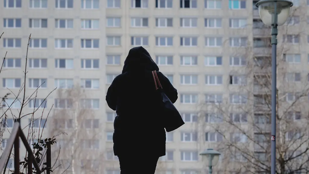Die-Silhouette-einer-Frau-zeichnet-sich-ab-vor-Wohnbloecken-im-Berliner-Bezirk-Marzahn-aufgenommen-in-Berlin-19-02-2026