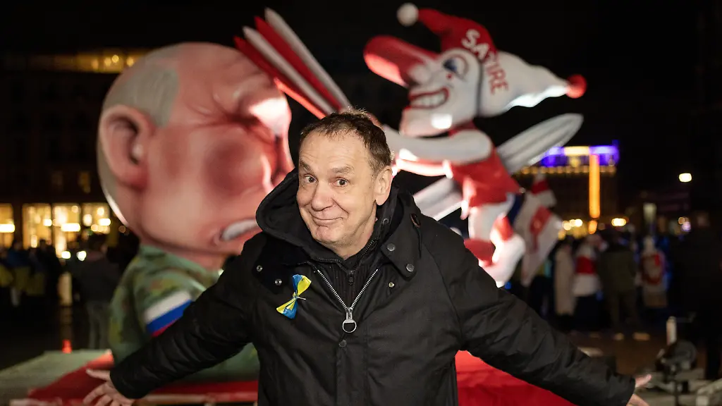 Kuenster-Jacques-Tilly-vor-seinem-Mottwagen-Putin-spiesst-den-Duesseldorfer-Hoppeditz-auf-Kundgebung-auf-dem-Roncalliplatz-in-Koeln-anlaesslich-des-Jahrestages-des-russischen-Grossangriffs-auf-die-Ukraine-Veranstalter-rufen-zur-Solidaritaet-mit-der-Ukraine-sowie-zur-Unterstuetzung-von-Frieden-Souveraenitaet-und-Menschenrechten-auf-Die-Veranstaltung-richtet-sich-an-Buergerinnen-und-Buerger-die-ein-Zeichen-gegen-den-Krieg-und-fuer-internationale-Solidaritaet-setzen-wollen