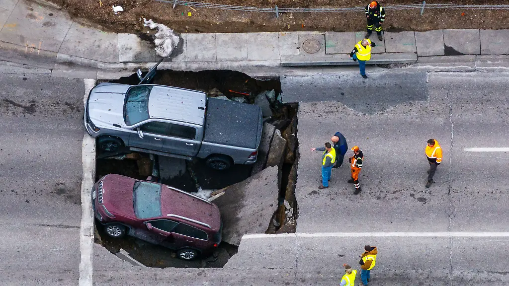 Beamte-begutachten-einen-Unfall-bei-dem-zwei-Fahrzeuge-auf-der-Pacific-Street-oestlich-der-67th-Street-in-Omaha-in-ein-Sinkloch-gestuerzt-sind
