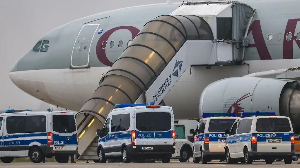 Polizeifahrzeuge-stehen-vor-einem-Flugzeug-der-Qatar-Airways-auf-dem-Flughafen-Leipzig-Halle-Wie-eine-Sprecherin-des-Bundesinnenministeriums-bestaetigte-startet-das-Flugzeug-vom-Flughafen-in-Leipzig-aus-mit-81-Menschen-an-Bord-um-diese-in-ihr-Herkunftsland-Afghanistan-zurueckzubringen-Deutschland-schiebt-damit-zum-zweiten-Mal-seit-der-Machtuebernahme-durch-die-Taliban-im-August-2021-afghanische-Staatsangehoerige-in-ihr-Herkunftsland-ab