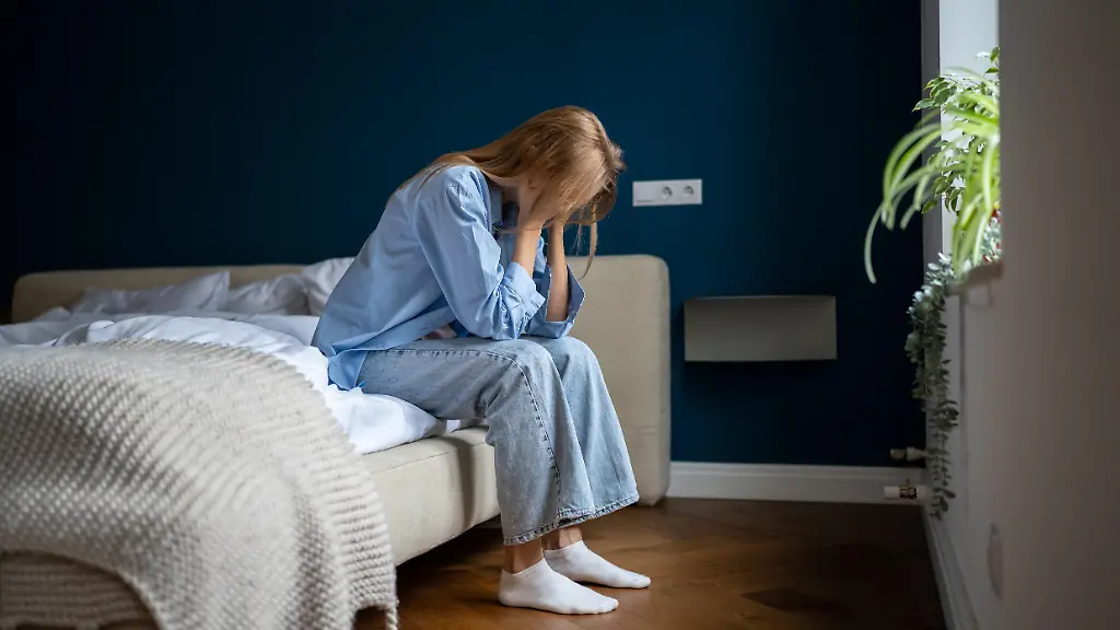 ppy-loneliness-woman-lost-in-thoughts-sitting-on-bed-holding-head-in-hand-at-home-Negative-emotional-pressure-on-female