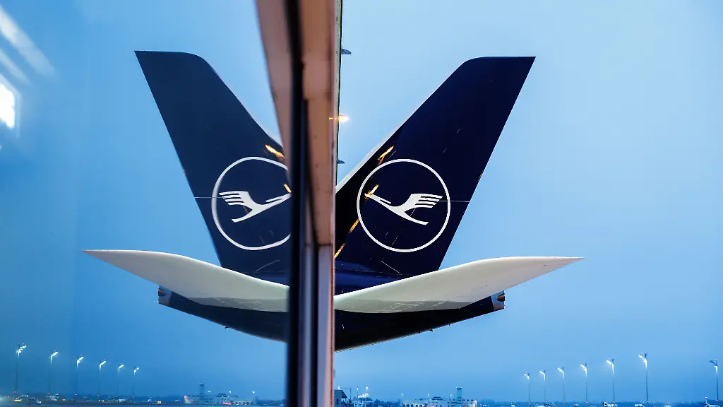 Die-Flosse-von-einem-Flugzeug-der-Fluggesellschaft-Lufthansa-Airbus-A380-800-ragt-am-Abend-aus-einem-Hangar-der-Lufthansa-Technik-AG-auf-dem-Flughafengelaende-vom-vom-Flughafen-Muenchen-Bayern-Deutschland-Der-Flughafen-Muenchen-Franz-Josef-Strauss-MUC-wird-von-der-Flughafen-Muenchen-GmbH-betrieben-Die-Lufthansa-Group-ist-ein-weltweit-fuehrender-Luftverkehrskonzern-und-die-groesste-Fluggesellschaft-in-Europa