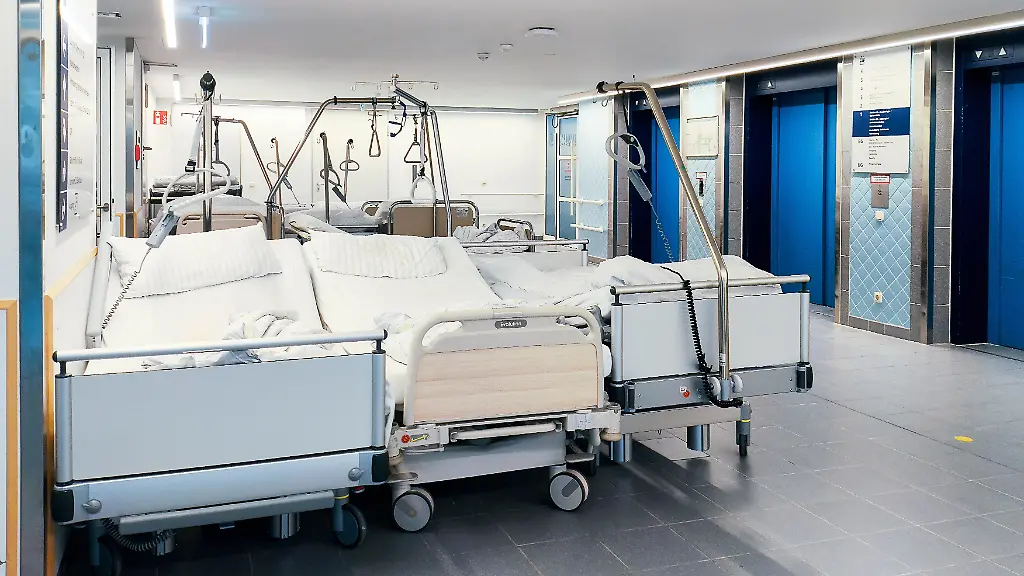 Mehrere-gebrauchte-Krankenhausbetten-stehen-unbesetzt-auf-einem-Flur-einer-Klinik-Die-Betten-wurden-bereits-genutzt-und-sind-aktuell-nicht-belegt
