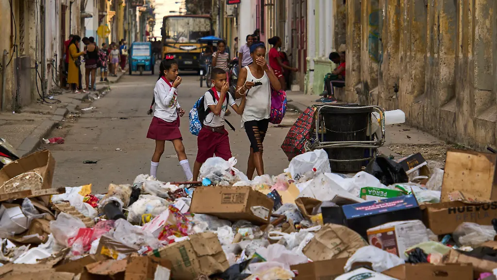 17-02-2026-Kuba-Havanna-Menschen-halten-sich-die-Nase-zu-als-sie-eine-Strasse-mit-Muell-passieren
