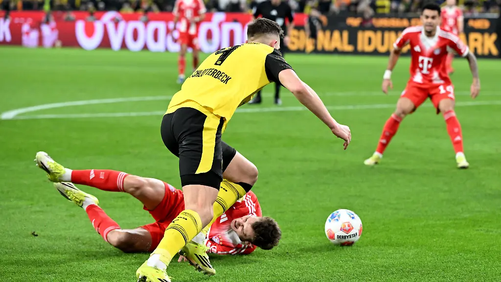 Fussball-Maenner-Bundesliga-Borussia-Dortmund-FC-Bayern-Muenchen-Spieltag-24-Signal-Iduna-Park-Nico-Schlotterbeck-Borussia-Dortmund-vorne-foult-Josip-Stanisic-Bayern-Muenchen-im-Sechszehnmeterraum-WICHTIGER-HINWEIS-Gemaess-den-Vorgaben-der-DFL-Deutsche-Fussball-Liga-bzw-des-DFB-Deutscher-Fussball-Bund-ist-es-untersagt-in-dem-Stadion-und-oder-vom-Spiel-angefertigte-Fotoaufnahmen-in-Form-von-Sequenzbildern-und-oder-videoaehnlichen-Fotostrecken-zu-verwerten-bzw-verwerten-zu-lassen