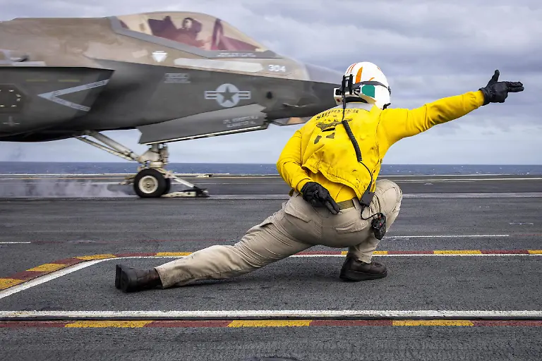 U-S-Navy-Lt-Cmdr-Jarrett-Walden-signals-an-F-35C-Lightning-II-attached-to-Marine-Fighter-Attack-Squadron-VMFA-314-as-it-launches-from-the-flight-deck-of-Nimitz-class-aircraft-carrier-USS-Abraham-Lincoln-CVN-72-on-Jan-4-2026-The-Abraham-Lincoln-Carrier-Strike-Group-is-underway-conducting-routine-operations-in-the-U-S-7th-Fleet-area-of-operations-Units-assigned-to-7th-Fleet-conduct-regular-Indo-Pacific-patrols-to-deter-aggression-strengthen-alliances-and-partnerships-and-advance-peace-through-strength-U-S-Navy-photo-by-Mass-Communication-Specialist-Seaman-Samuel-Evarts-04SIPA-Sipa-07851-Credit-U-S