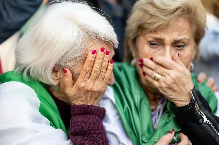 Zwei-Frauen-reagieren-auf-einer-Iran-Demonstration-am-Potsdamer-Platz-nachdem-auf-der-Buehne-der-angebliche-Tod-von-Staatsoberhaupt-Chamenei-verkuendet-wurde