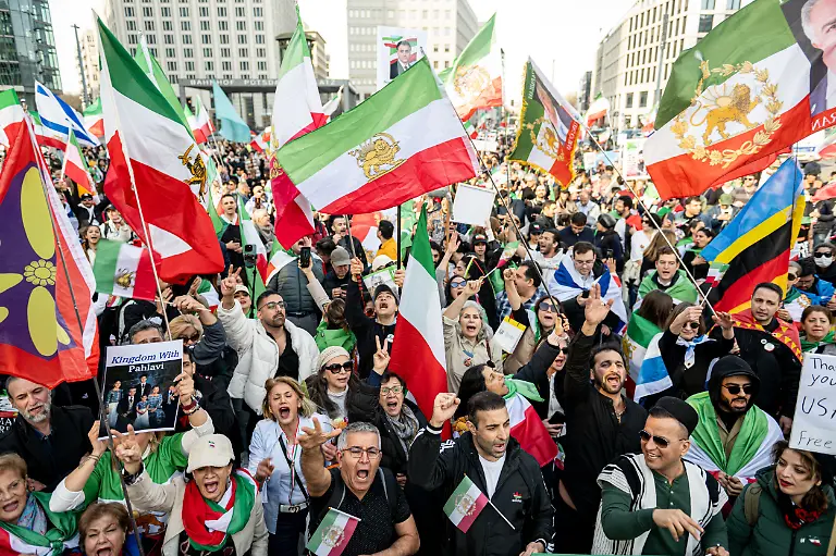 Menschen-jubeln-auf-einer-Iran-Demonstration-am-Potsdamer-Platz-nachdem-auf-der-Buehne-der-angebliche-Tod-von-Staatsoberhaupt-Chamenei-verkuendet-wurde