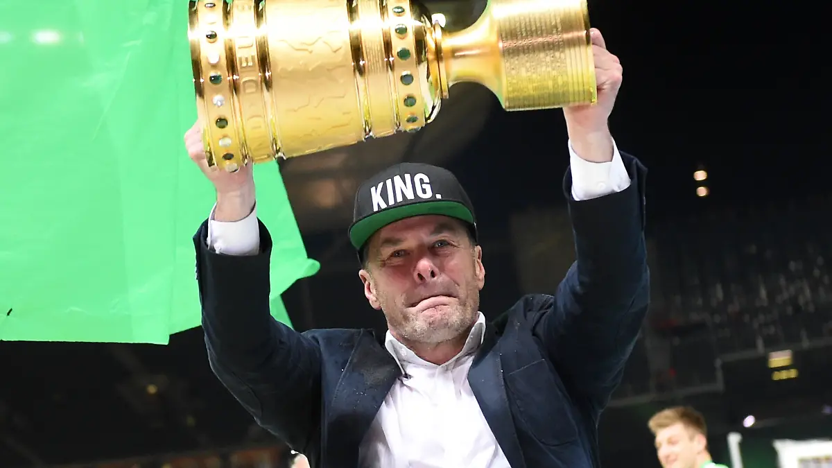 ARCHIV-Fussball-DFB-Pokal-Finale-Borussia-Dortmund-VfL-Wolfsburg-am-30-05-2015-im-Olympiastadion-in-Berlin-Wolfsburgs-Trainer-Dieter-Hecking-traegt-eine-Basecap-mit-der-Aufschrift-King-und-stemmt-DFB-Pokal-in-die-Luft-Foto-Maurizio-Gambarin-dpa-zu-dpa-Wolfsburgs-King-gestuerzt-Hecking-erstmals-beurlaubt-am-17-10