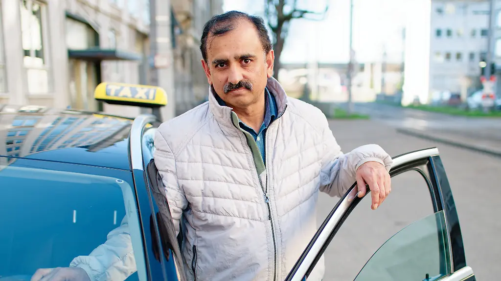 Taxifahrer-Muhammad-A-steht-an-seinem-Taxi-an-der-Stelle-wo-er-vor-einem-Jahr-den-Taeter-bei-seiner-Amokfahrt-durch-die-Mannheimer-Innenstadt-stoppte