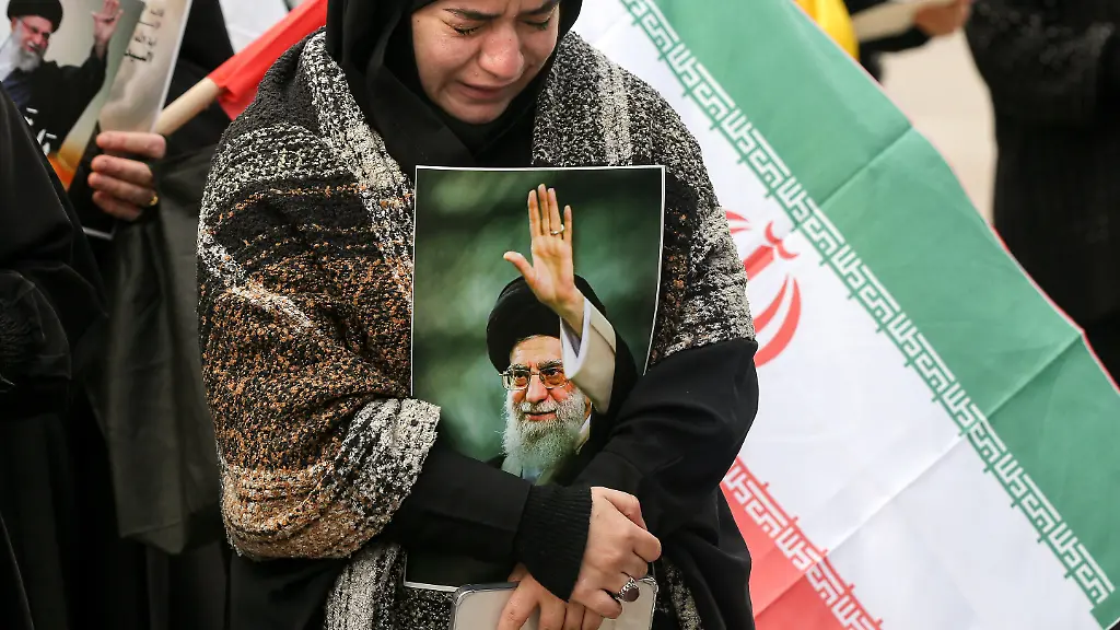 Ein-pro-iranischer-Hisbollah-Anhaenger-der-ein-Bild-des-iranischen-Obersten-Fuehrers-Ajatollah-Ali-Chamenei-in-der-Hand-haelt-weint-waehrend-einer-Kundgebung