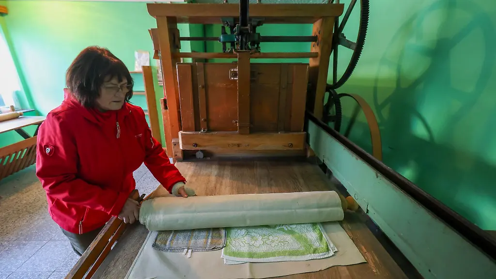 Annerose-Illing-mangelt-die-Waesche-ihrer-betagten-Mutter-mit-einer-historischen-Kaltmangel