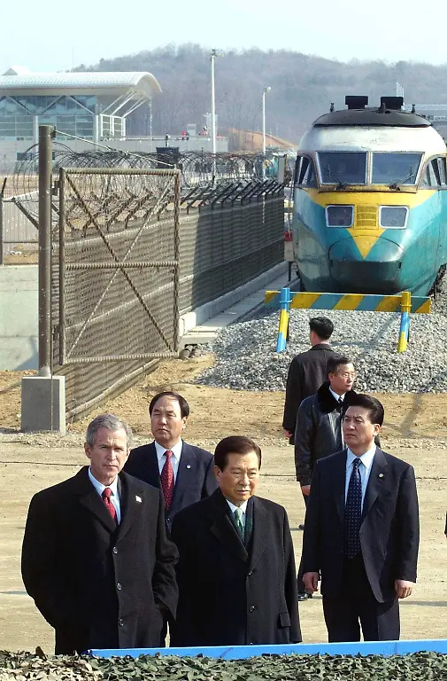 Der-amerikanische-Praesident-George-W-Bush-l-und-sein-suedkoreanischer-Amtskollegen-Kim-Dae-Jung-M-besuchen-am-20-2-2002-die-entmilitarisierte-Zone-zwischen-Sued-und-Nordkorea-in-Imjingak-nahe-der-Dorasan-Bahnstation-Beim-vorhergehenden-Treffen-mit-dem-suedkoreanischen-Praesidenten-in-Seoul-versicherte-Bush-seine-Unterstuetzung-fuer-die-Annaeherungspolitik-Seouls-zu-Nordkorea-Die-USA-haetten-nicht-die-Absicht-Nordkorea-anzugreifen-Bush-hatte-Nordkorea-im-Rahmen-des-Kampfes-gegen-den-Terrorismus-fs12-fs16-in-einem-Zug-mit-Iran-und-Irak-als-Teil-einer-Achse-des-Boesen-gebrandmarkt-Bush-der-sich-auf-einer-Ost-Asienreise-befindet-reiste-am-Tag-darauf-nach-China-weiter