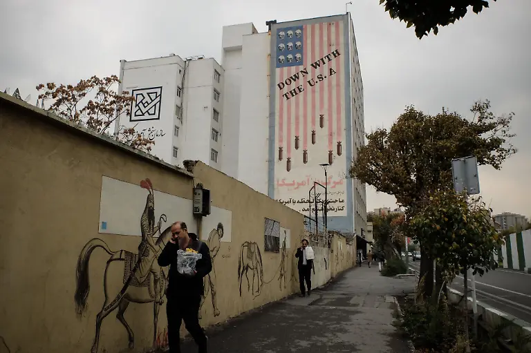 November-19-2019-Tehran-Iran-Pedestrians-pass-a-giant-wall-mural-reading-Down-With-The-USA-on-a-street-in-Tehran-Iran-Three-security-personnel-have-been-killed-by-rioters-in-Iran-the-latest-deaths-in-protests-that-showed-no-sign-of-subsiding-Tuesday-despite-a-wave-of-arrests-and-internet-shutdown-The-deaths-take-to-at-least-five-the-number-of-people-confirmed-to-have-been-killed-in-the-nationwide-demonstrations-that-erupted-on-Friday-against-a-shock-decision-to-impose-petrol-price-hikes-The-situation-on-the-streets-remains-unclear-largely-due-to-the-government-imposed-internet-outage-which-has-entered-the-third-day